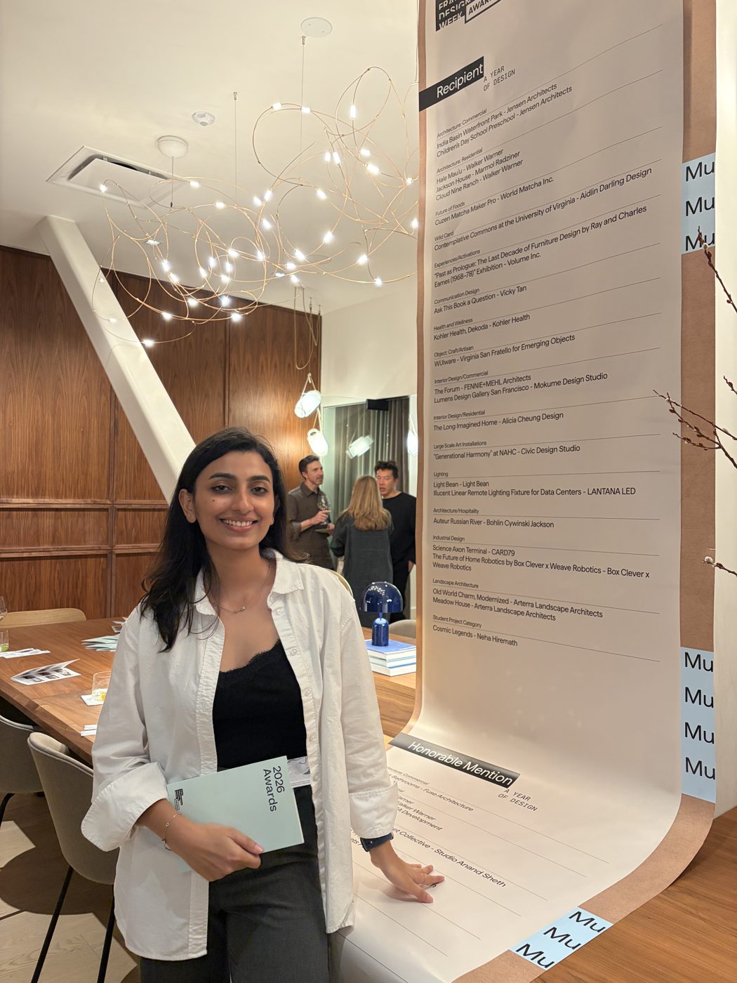 Neha at the awards night beside the wall of 2026 recipients